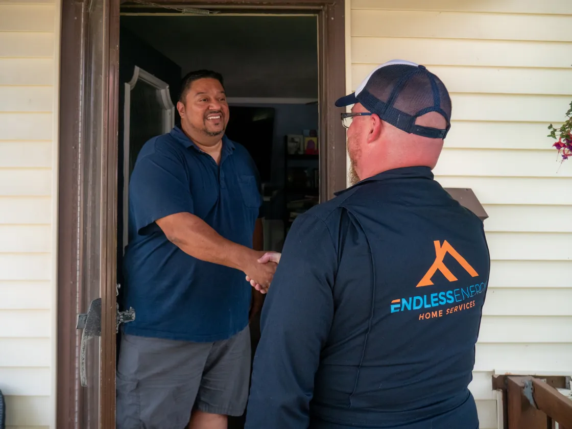 Endless Energy electrician shaking hands with a homeowner at the front door