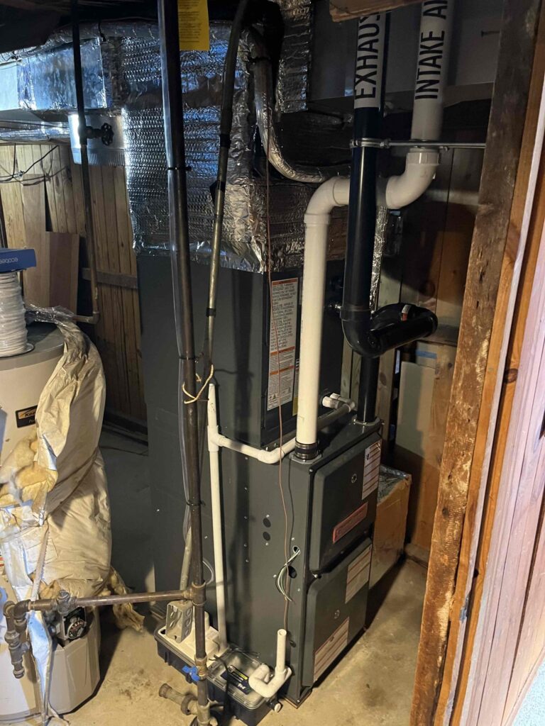 A residential HVAC furnace system installed in a basement by Endless Energy with insulated ducts, PVC piping, and surrounding utility equipment visible.