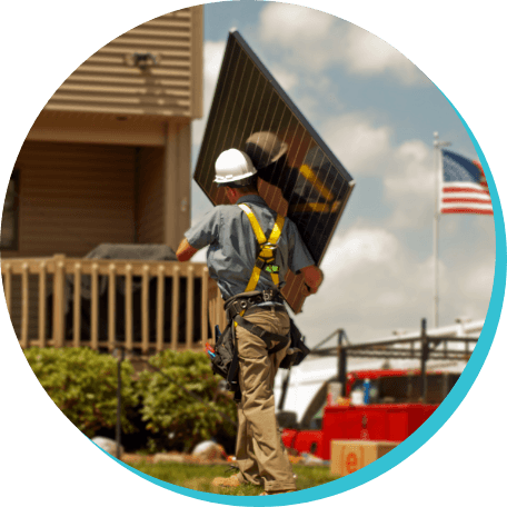 Endless Energy employee carrying solar panel to house