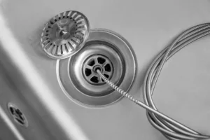 Cleaning of drain with plumber's snake, closeup